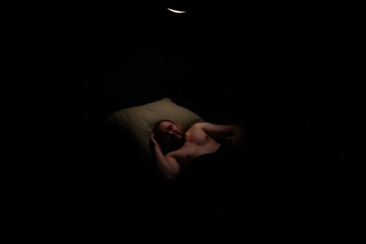 Homme dormant paisiblement dans une chambre sombre